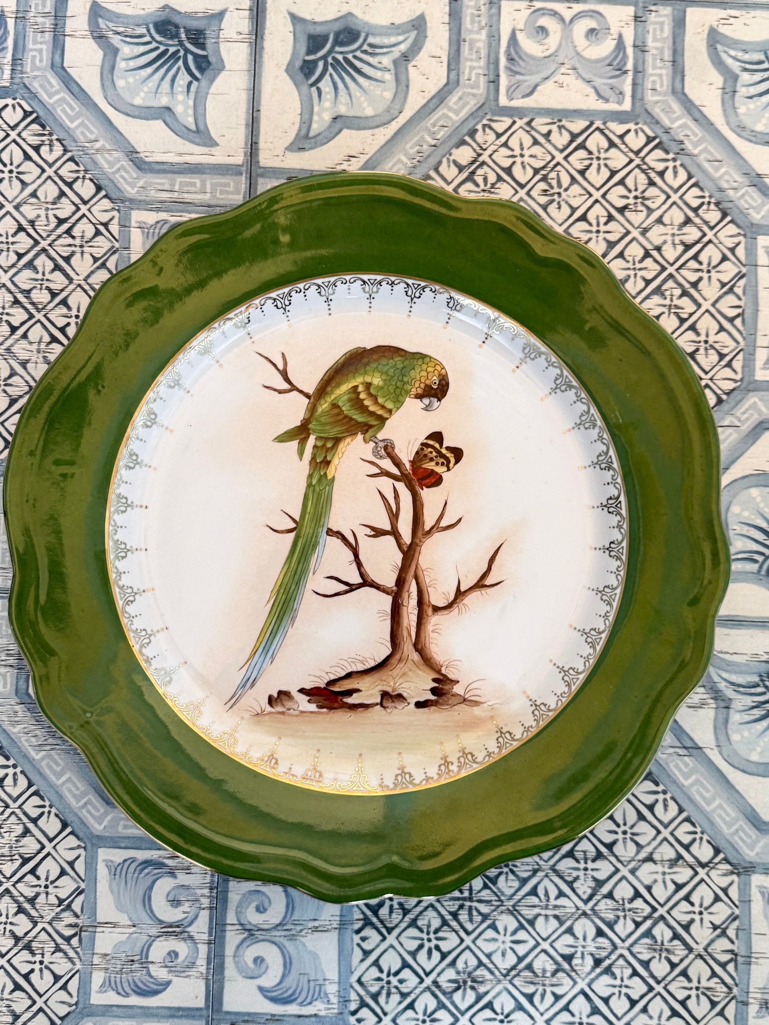 Decorative plate with a bird design on a patterned tile background