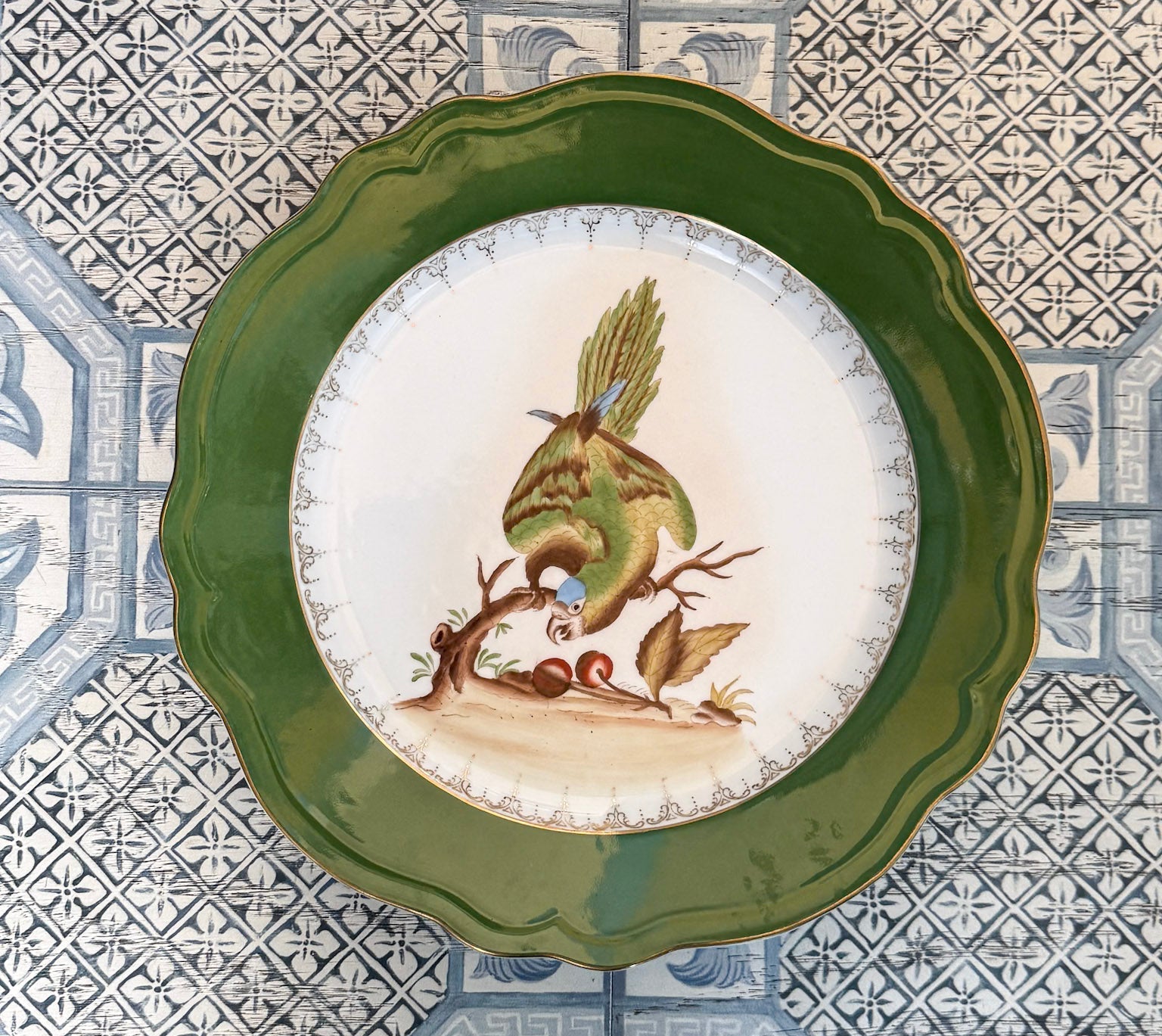 Decorative plate with a green rim on a patterned tile background