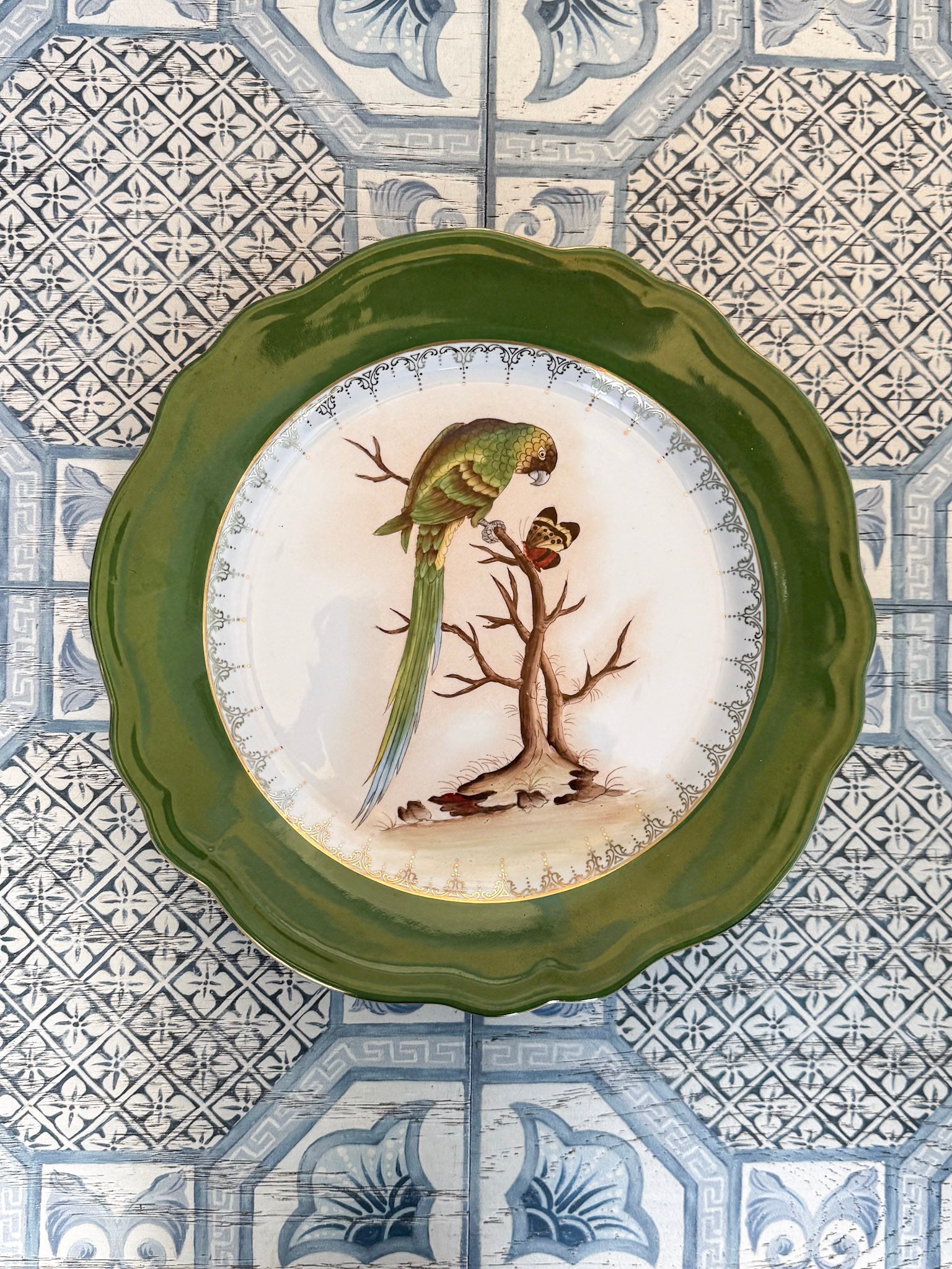 Decorative plate with a bird design on a patterned tile background