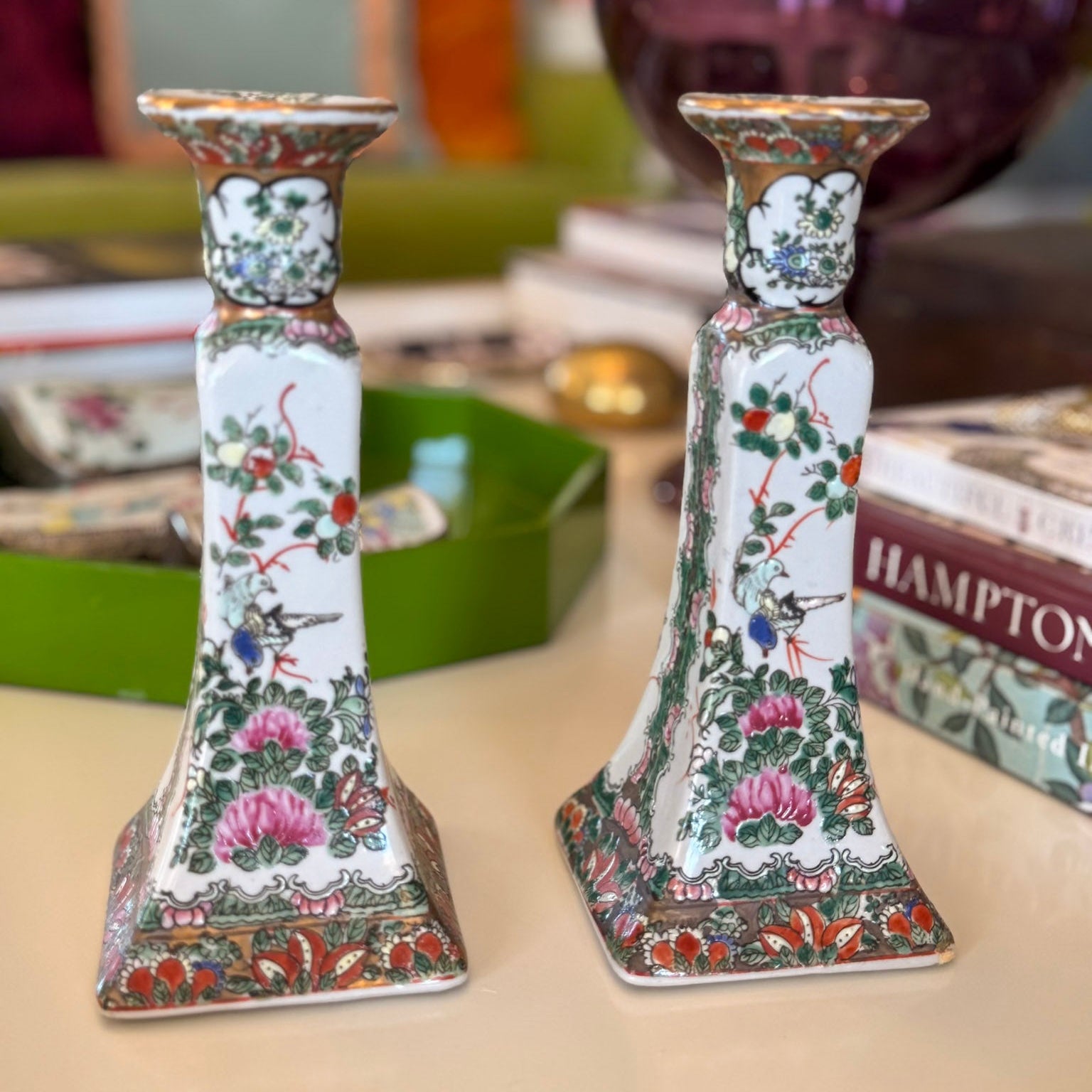 Pair of decorative candlesticks with floral patterns on a surface.