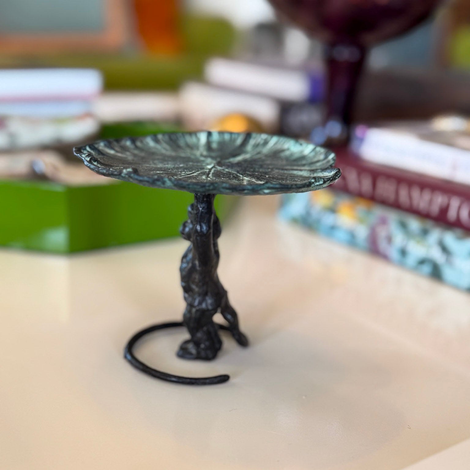 Decorative metal stand with leaf-like design on a surface