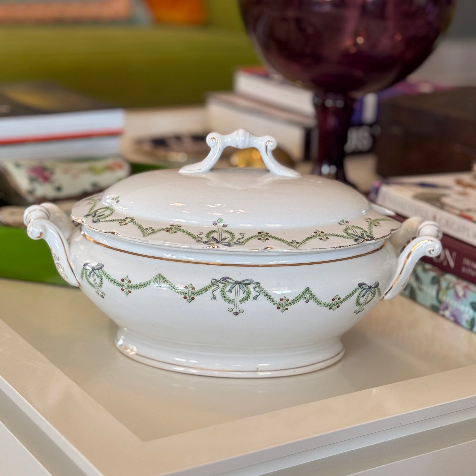 Decorative white tureen with green patterns on a table